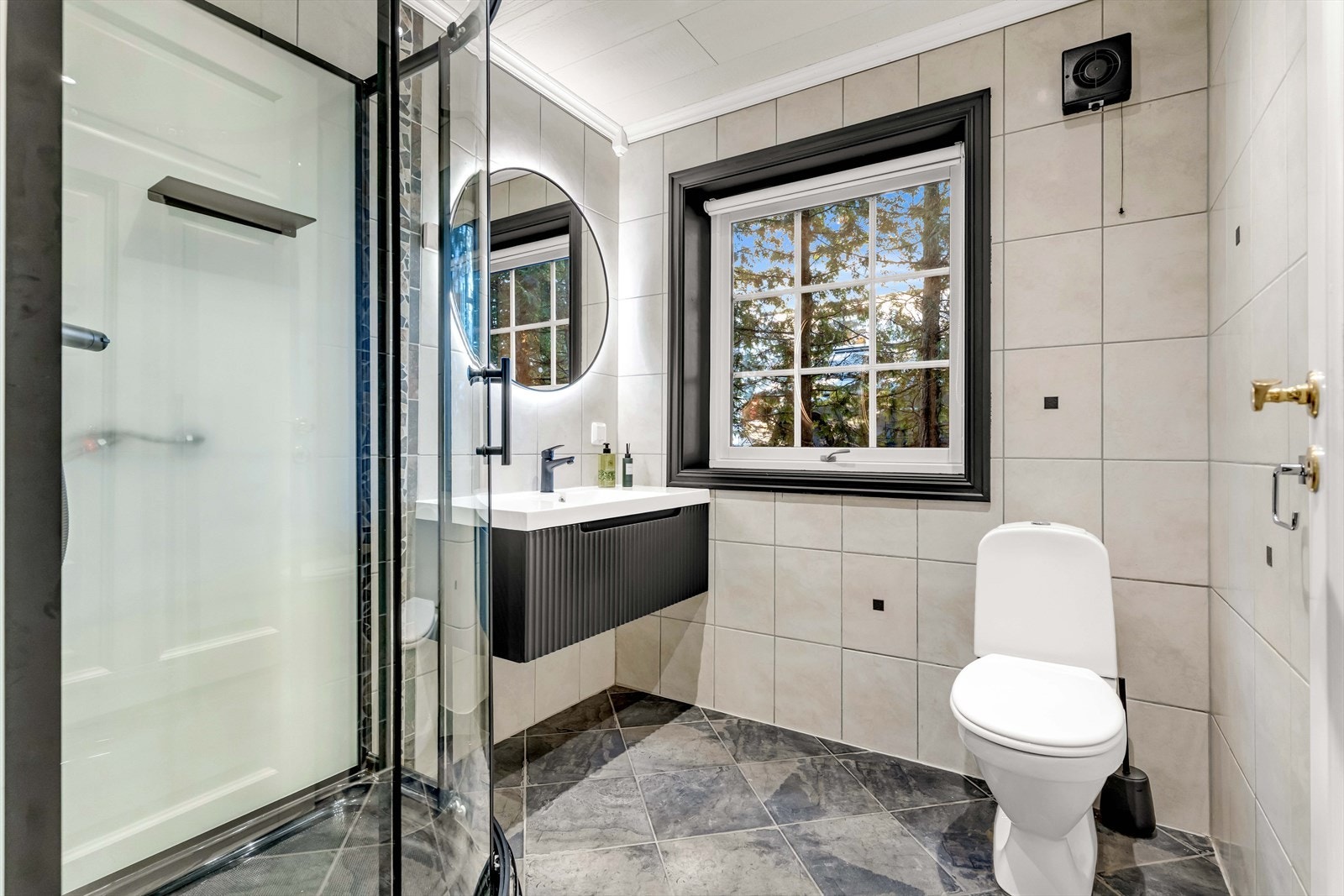 Etasjens bad har flislagt gulv med vannbåren gulvvarme, samt flislagte vegger og takplater i himling. Innredningen består av servantskap med nedfelt servant, underskuffer og 1-greps blandebatteri. I tillegg er det satt inn dusjkabinett og gulvstående toal Galleribilde