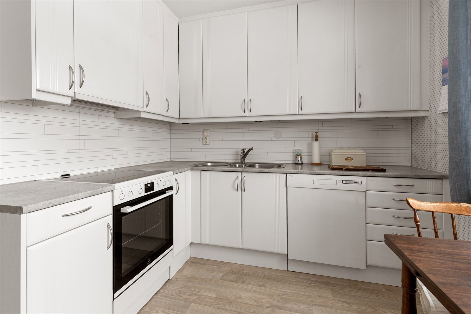 Kjøkkenet fremstår som velholdt og innholdsrikt, med laminert benkeplate for enkelt renhold Galleribilde