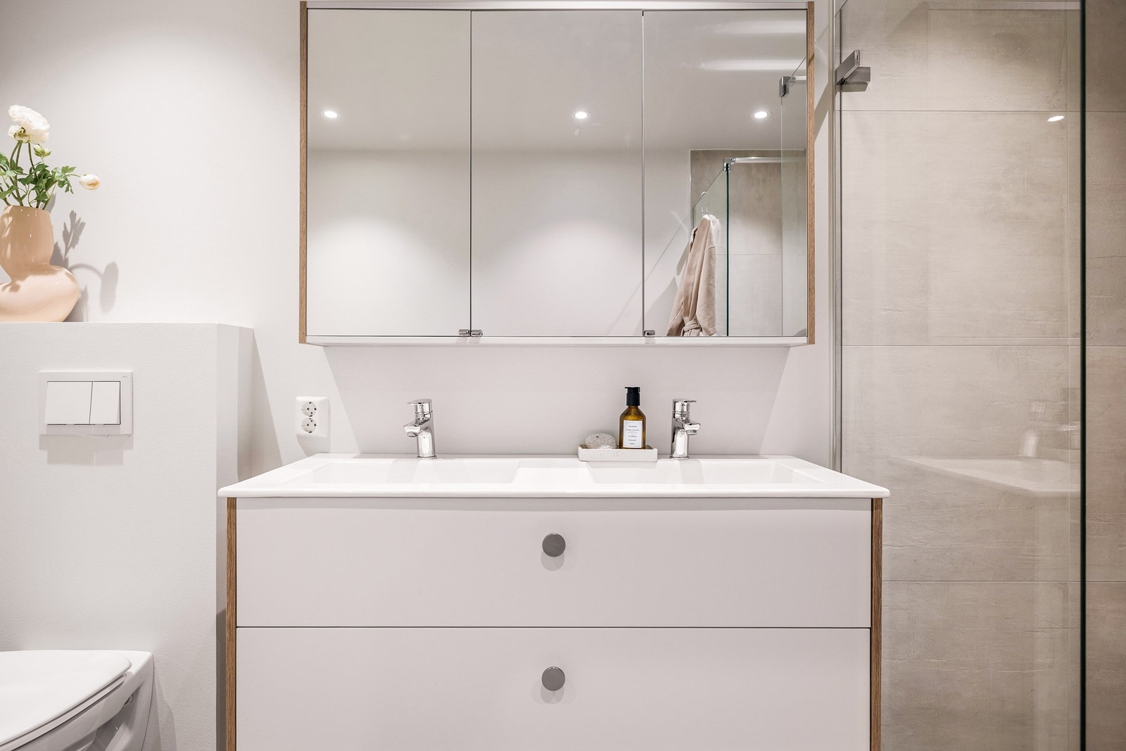 - God oppbevaringsplass i skap med speilfronter og store skuffer under servant - Galleribilde