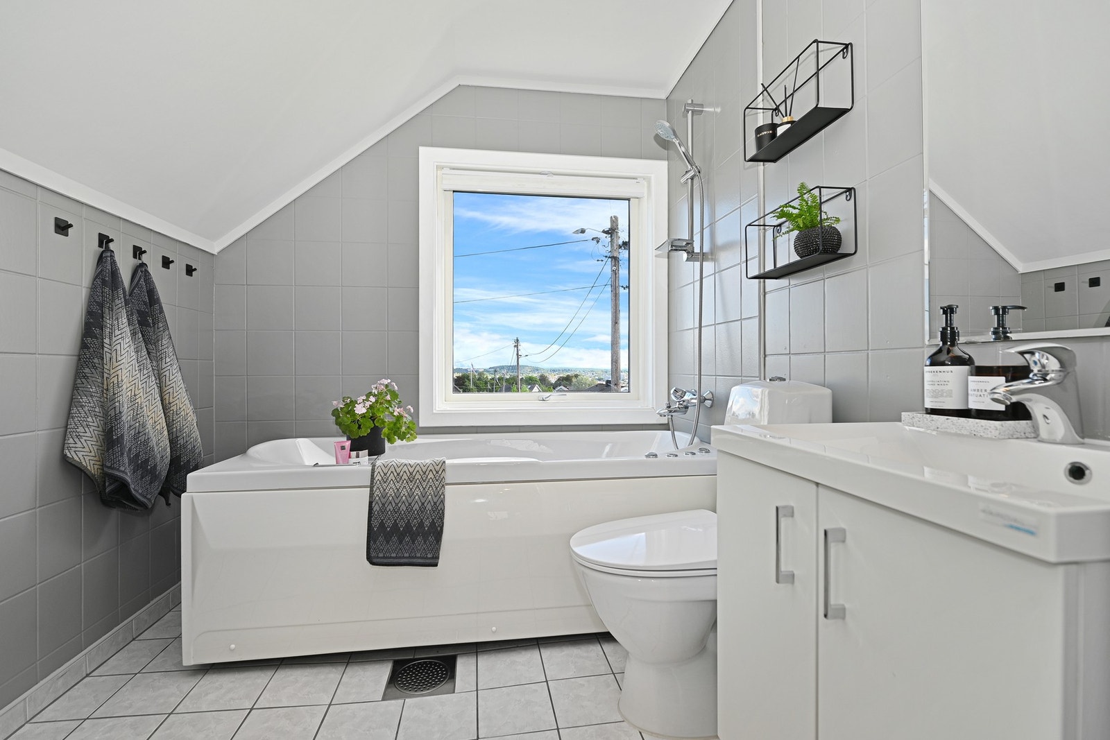 Badet i 2. etasje er praktisk plassert ved soverommene. Rommet er innredet med ed nedfelt servant, gulvfestet toalett og badekar med dusjmulighet. Galleribilde