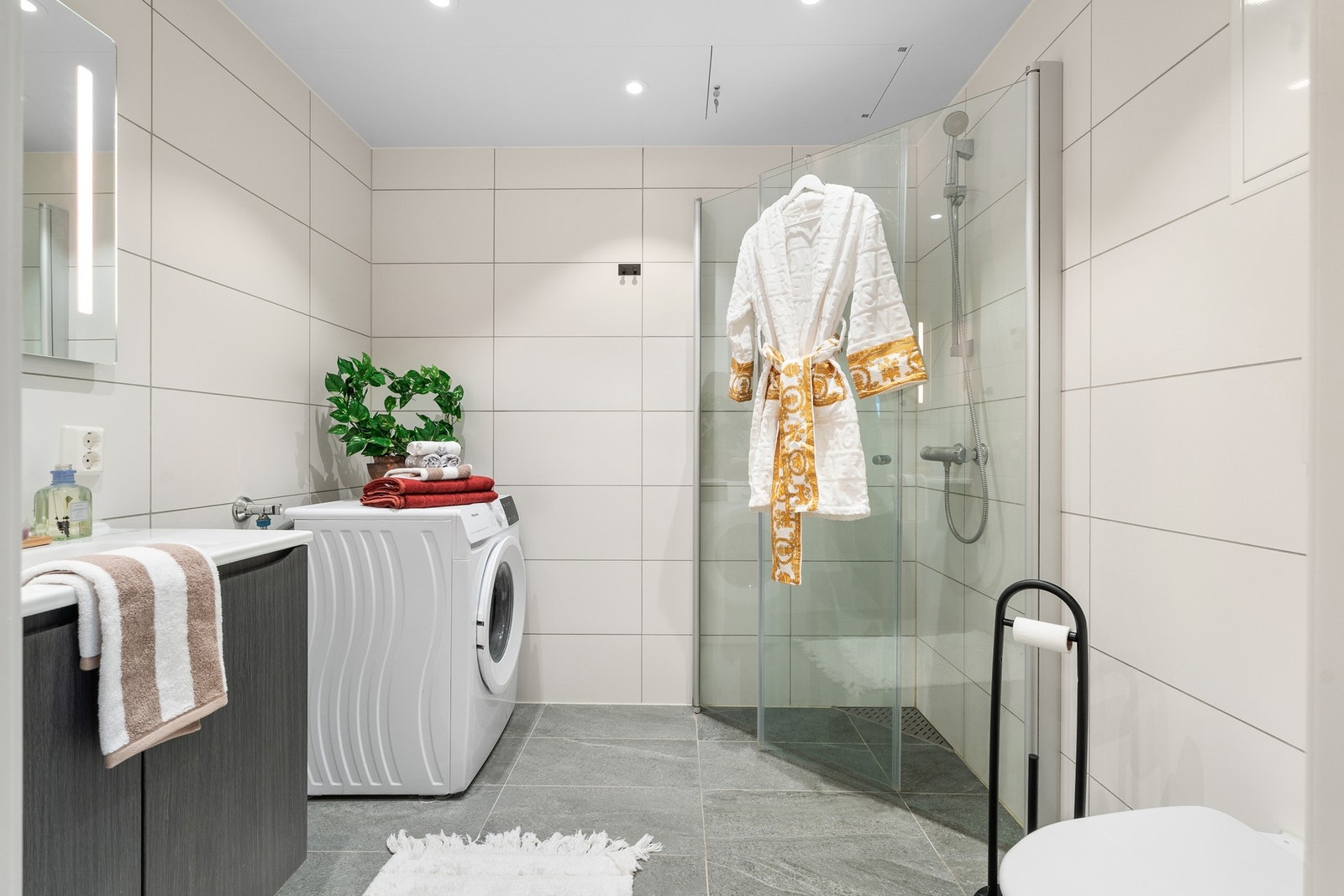 Lyst og stilfullt baderom. 60x60 flis på gulv med vannbåren varme. Veggene er også flislagte og i himling har du plater med innfelte spotter. Galleribilde