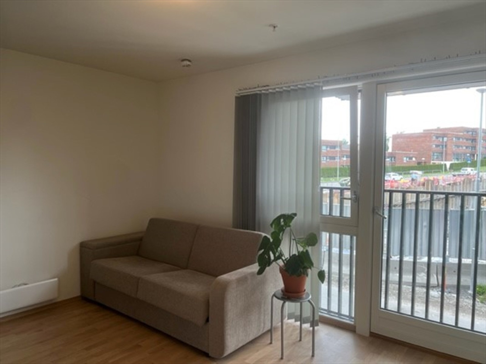 Stor vindusflate med utgang til fransk balkong. Lamellgardiner på vinduet for solskjerming. Galleribilde