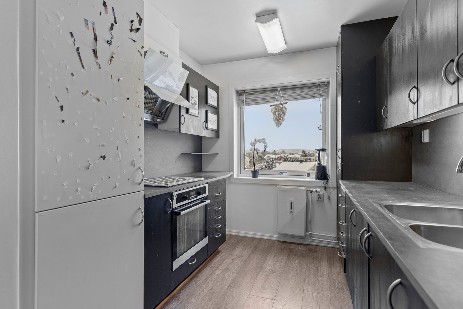 Kjøkkeninnredningen har en eldre standard. Innredningen har malte fronter, laminat benkeplater, oppvaskkum, ventilator, plater over
benk, belysning under overskap, integrert kjøl/fryseskap, stekeovn og induksjon platetopp. Galleribilde