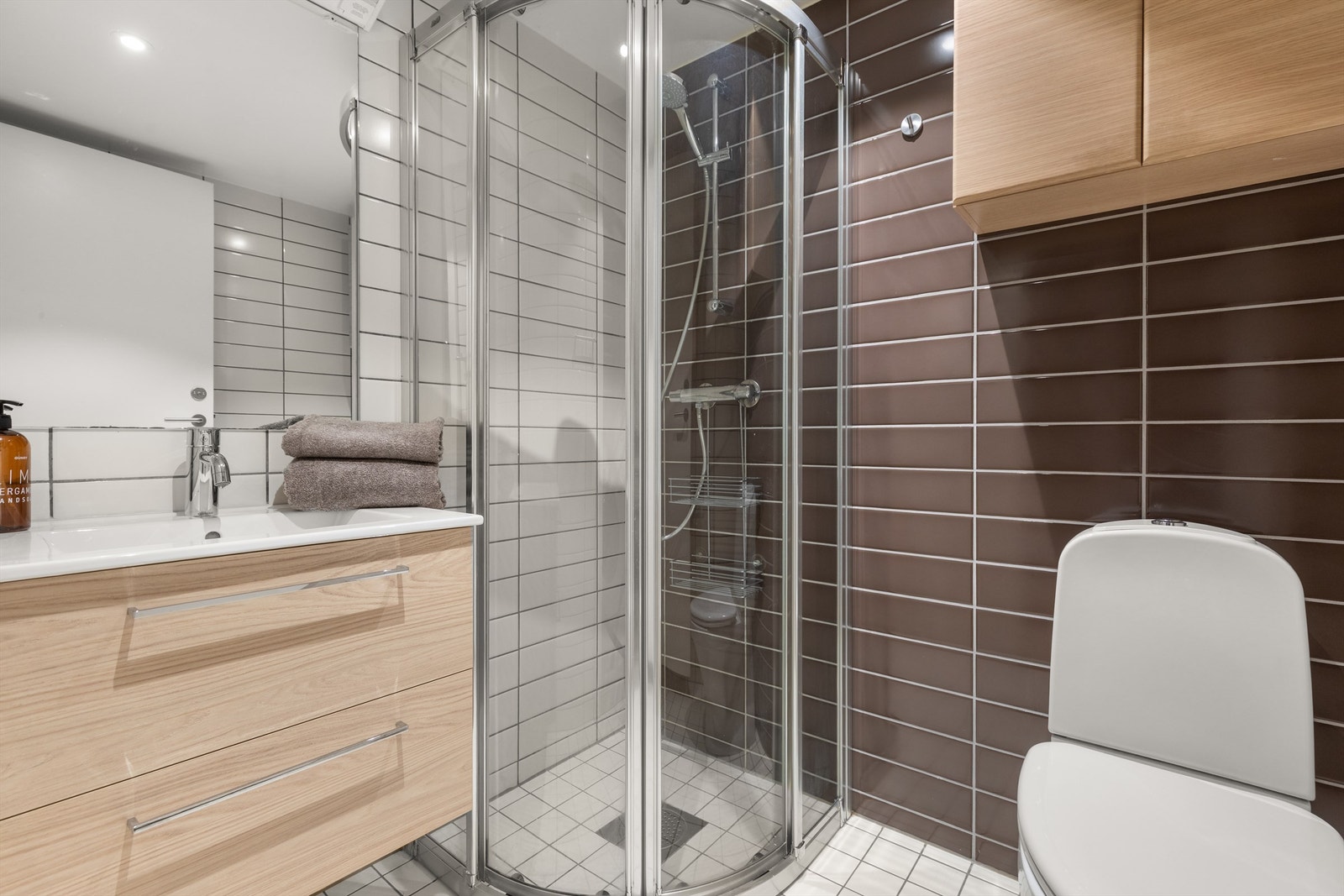 Badet har flislagt gulv og vegger med elektrisk gulvvarme. Badet er innredet med klosett, servant med innredning, speil m/lys og dusjhjørne med skyvbare glassdører. Mekanisk avtrekk sørger for behagelig inneklima. Galleribilde