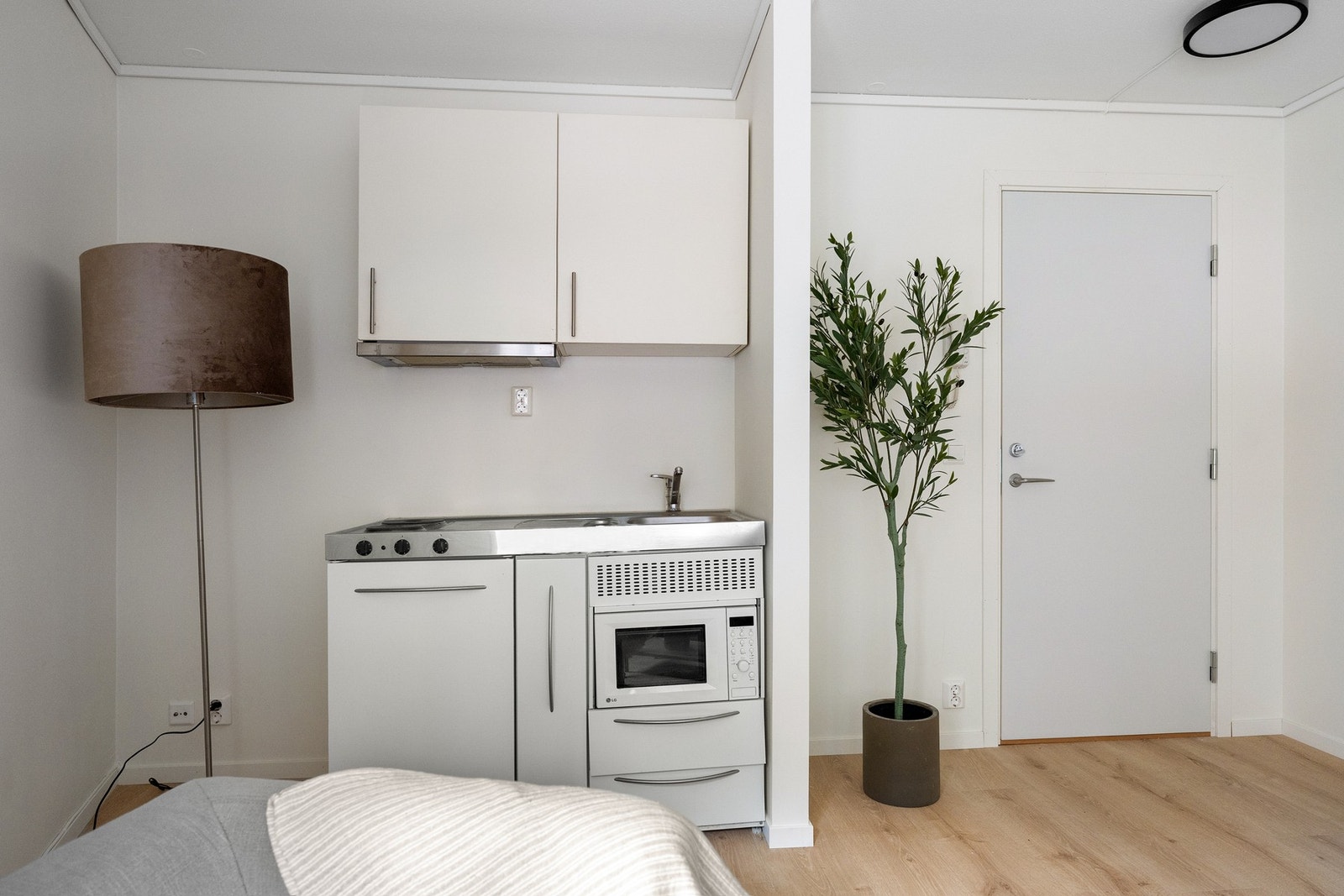 Pent kjøkken med glatte fronter og benkebeslag med vaskekum i rustfritt stål. Galleribilde