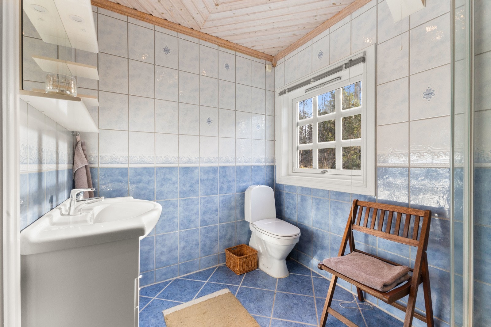 Rommet er utstyrt med dusjkabinett, servant med innredning og toalett. Galleribilde