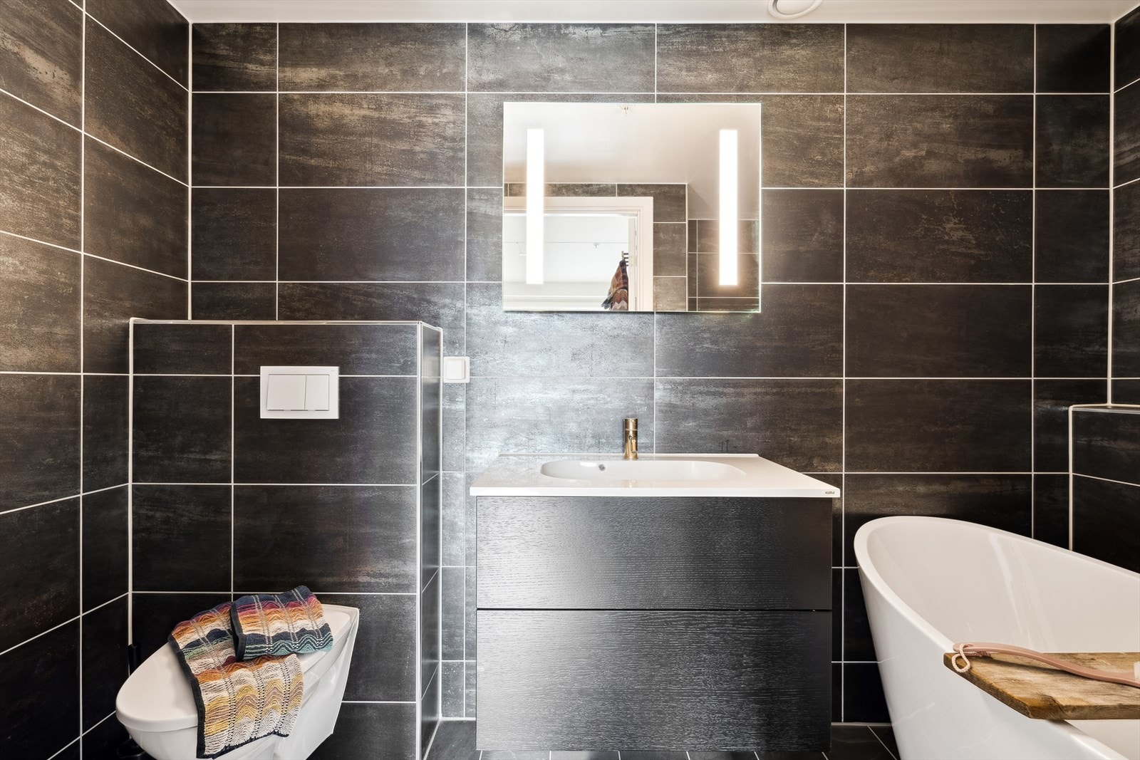 Dette badet er utstyrt med badekar, vegghengt wc og servantinnredning med skuffer Galleribilde