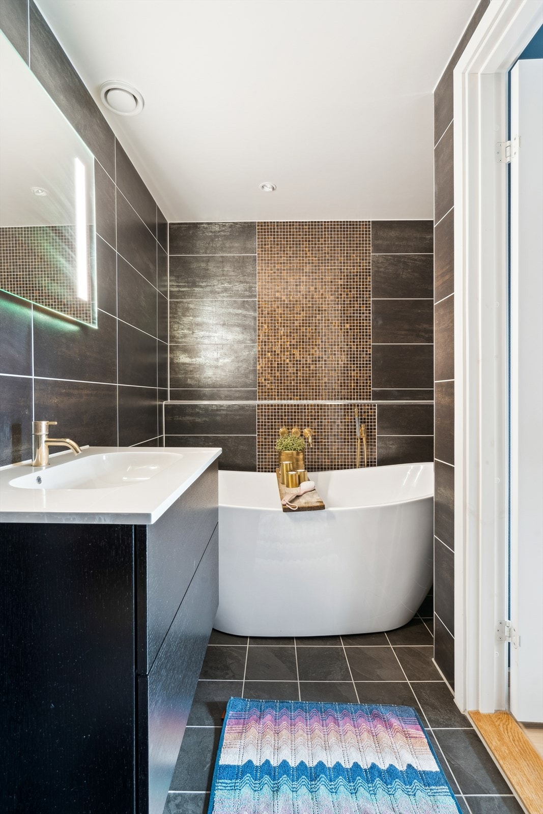 Eget bad tilknyttet hovedsoverommet med flislagte overflater og varmekabler i gulvet Galleribilde