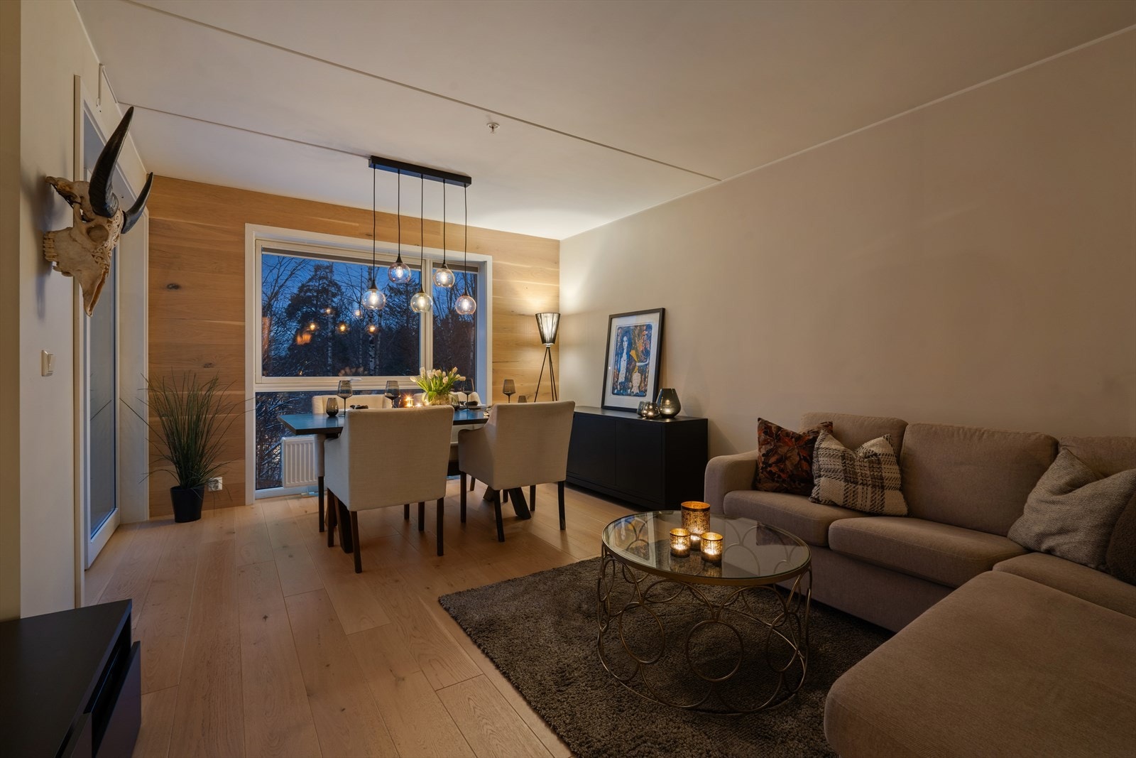 Den gjennomgående løsningen og de store vinduene gir stuen en lys og luftig atmosfære Galleribilde