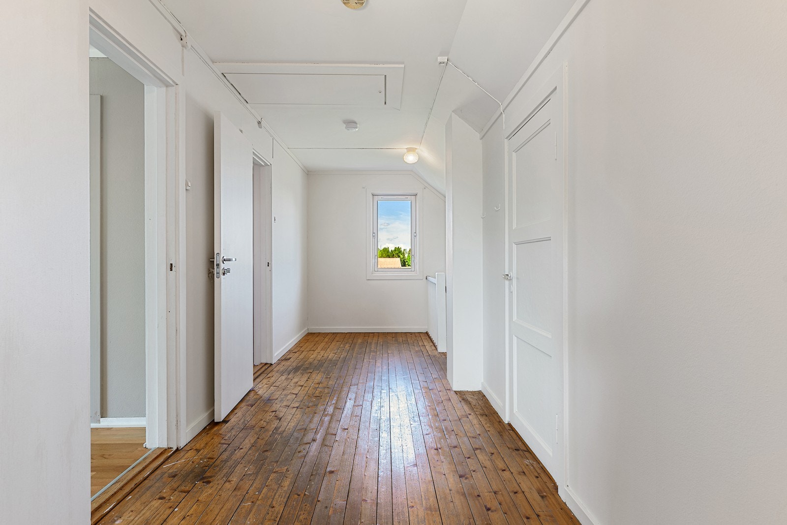 Gulv av furu gir en varm og naturlig følelse i gangen. Malte vegger og tak gir et rent og enkelt uttrykk. Galleribilde