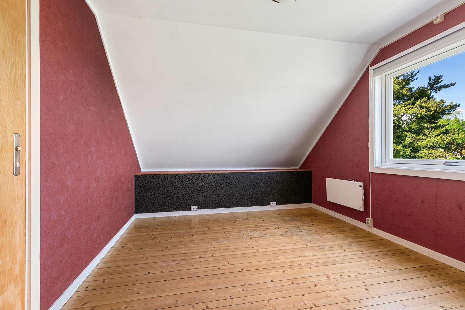 Andre etasjes første soverom har skråtak og tregulv, som gir rommet karakter og muligheter for personlig tilpasning. Galleribilde