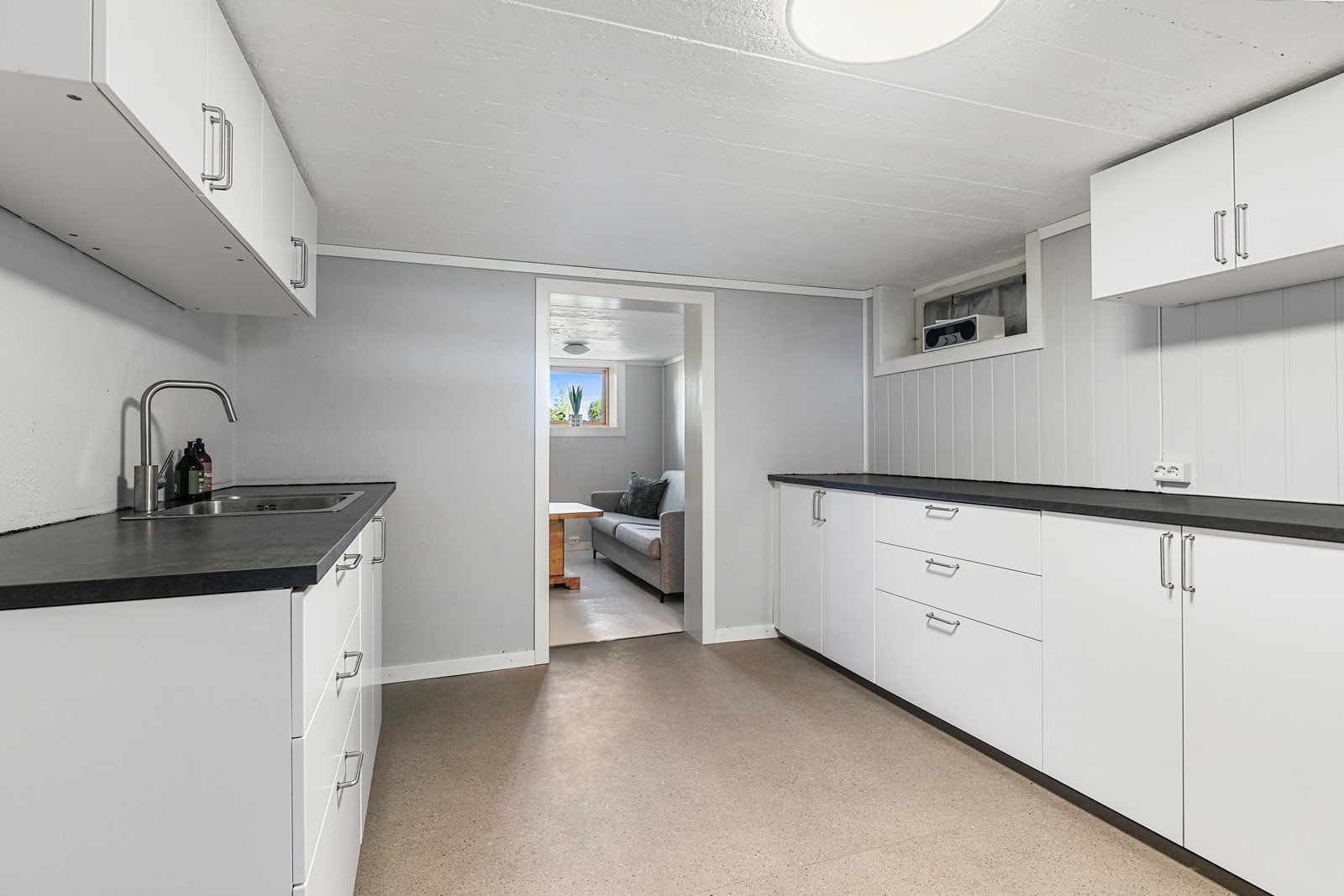 Kjøkkenet har innredning med glatte fronter og laminat benkeplate, med avsatt plass til kjøle/fryseskap. Galleribilde