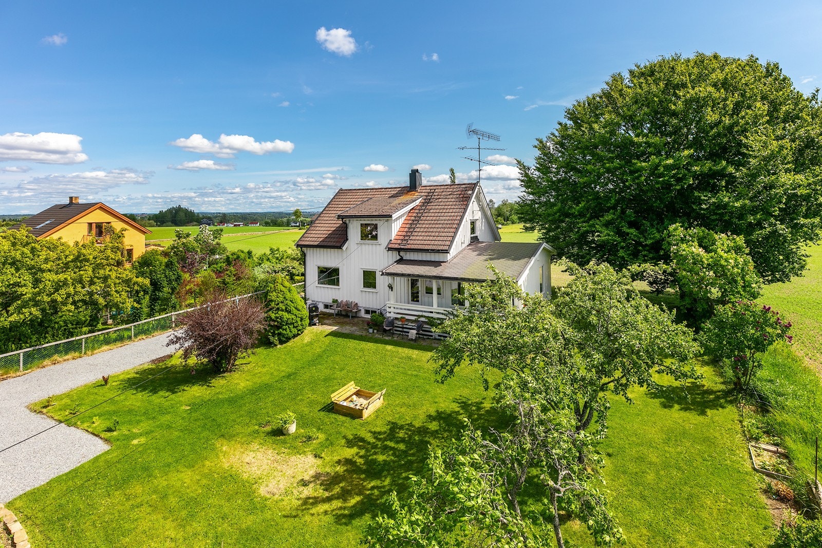 Sommerbilde:
Tomten har en stor, gammel tre som gir naturlig skygge og karakter. Galleribilde