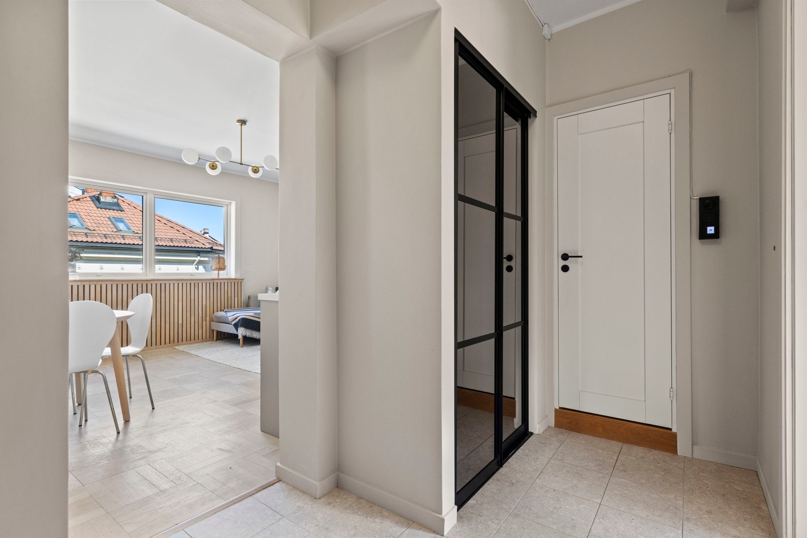 I entréen møtes du av et flislagt gulv og malte vegger som gir et stilrent førsteinntrykk. Den praktiske garderobeløsningen gjør det enkelt å holde orden på yttertøy og sko, og setter tonen for resten av leiligheten. Galleribilde