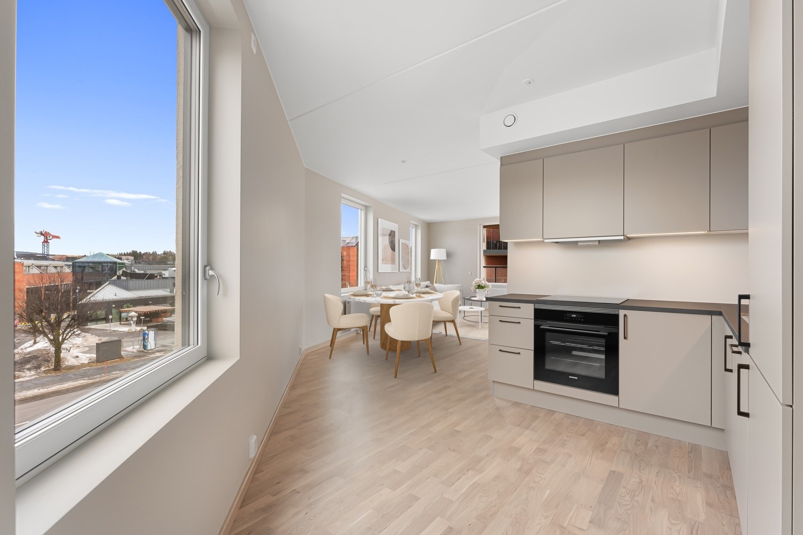 I en åpen løsning mot stuen finner du et stilrent, delikat HTH kjøkken. Bildet er virtuelt møblert. Galleribilde