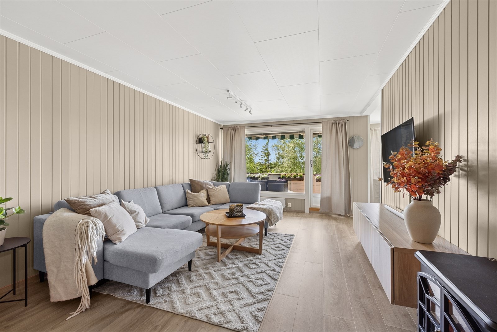 Innbydende og lys stue med store vindusflater ut mot vestvendt balkong. Galleribilde