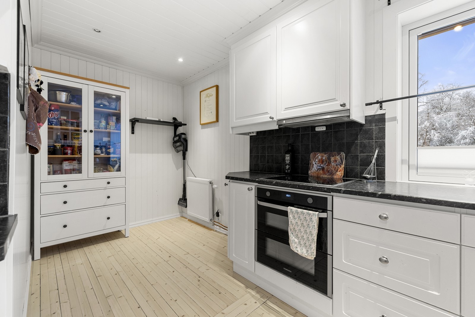 Det er profilerte fronter og laminatbenkeplate som gir rikelig med skap- og benkeplass. Kjøkkenet har i senere tid blitt omgjort større, for plass til egen spisegruppe. Galleribilde