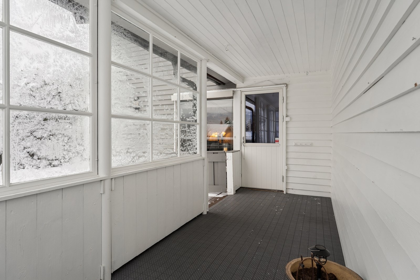 En liten del av terrassen har takoverbygg og er delvis innglasset. Galleribilde