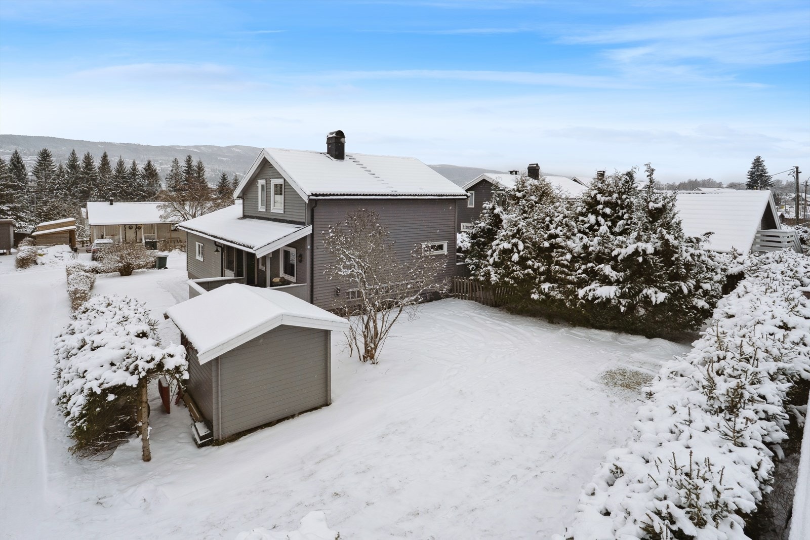 Deler av tomten er inngjerdet og tomten er pent opparbeidet med gressplen, beplantninger samt noe prydbusker. Det er anlagt asfalt ved innkjøring, og gress opp til inngangsparti til boligen. Parkering på egen grunn og i egen garasje. Galleribilde
