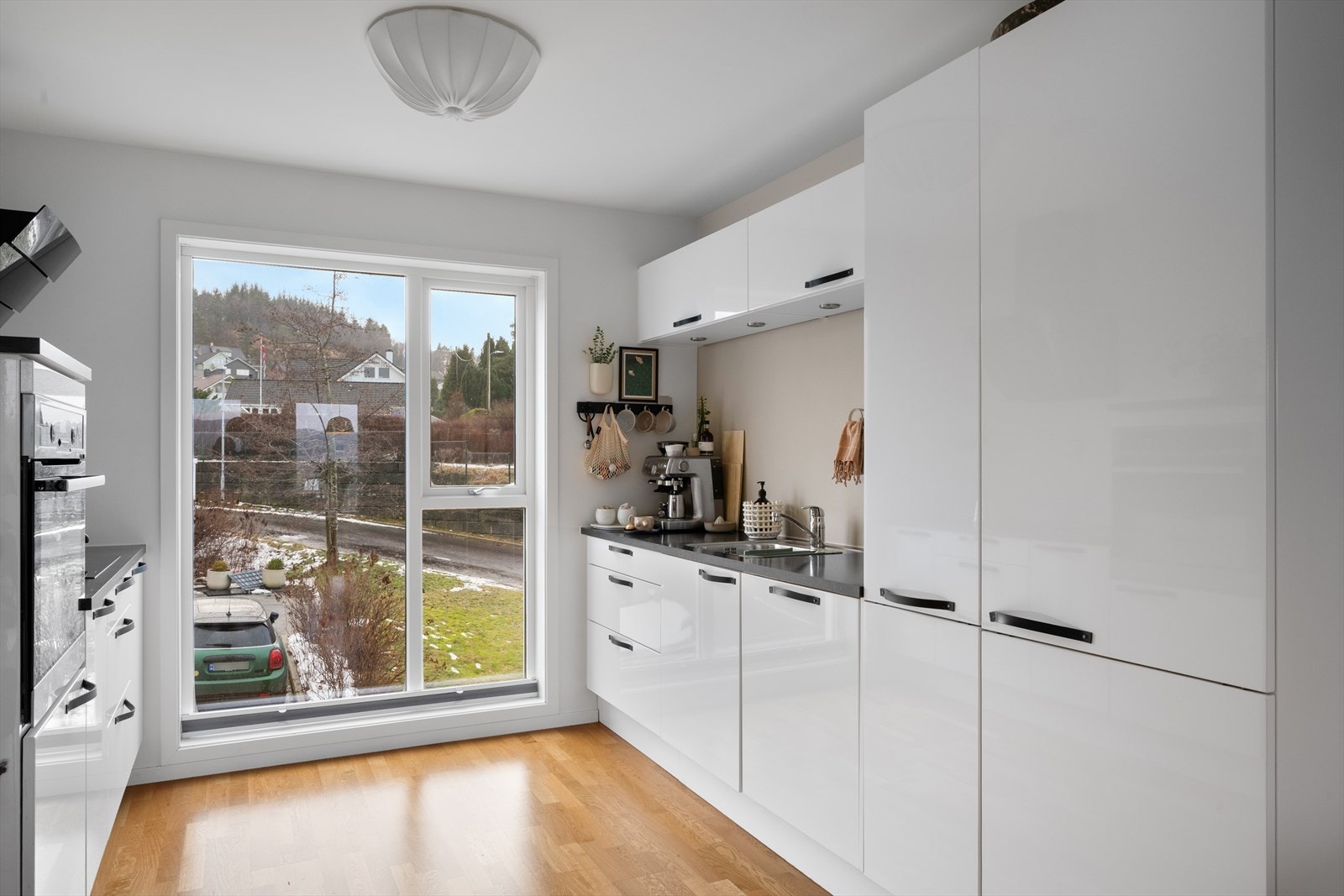 Innholdsrik kjøkkeninnredning i i hvit høyglans utførelse. Integrert platetopp, stekeovn, kjøl-/fryseskap og oppvaskmaskin medfølger. Galleribilde