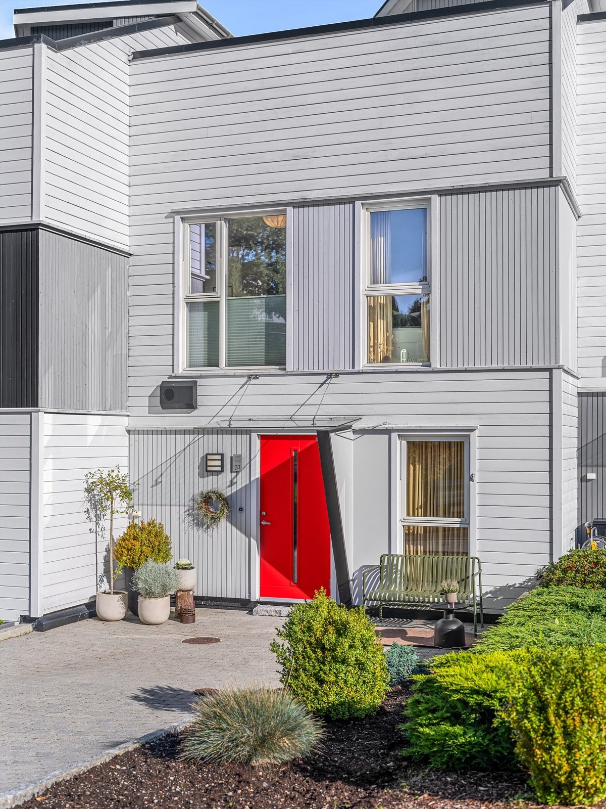 Pent opparbeidet og beplantet. Belegningsstein i gårdsrom og bed med vintergrønt ved inngangsparti. Plass til sittegruppe ved inngangspartiet. Galleribilde