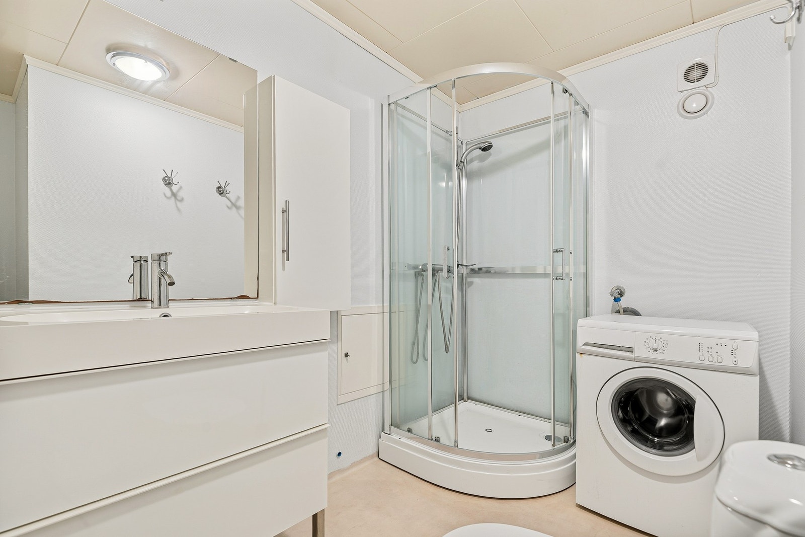 Badet i garasjen har dusjkabinett og opplegg for vaskemaskin. Galleribilde