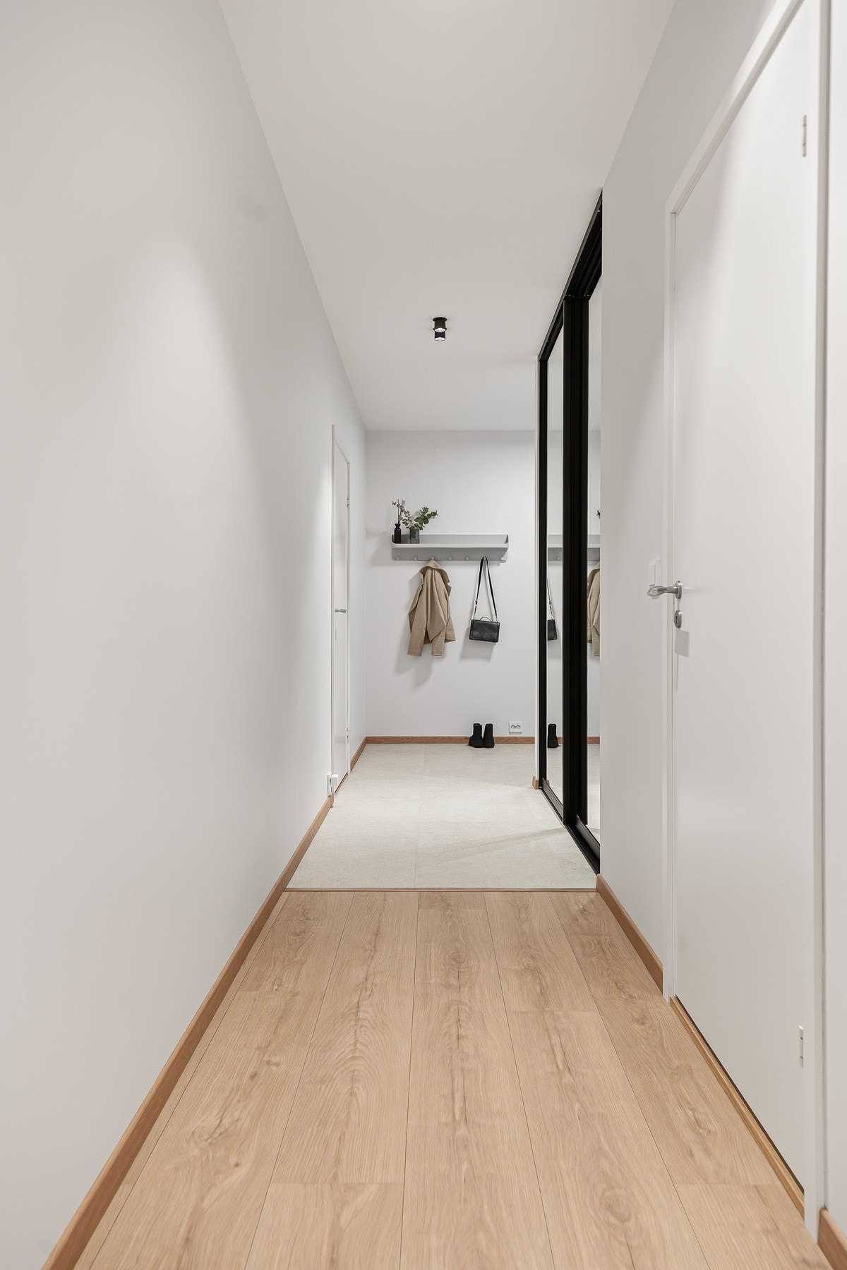 Det er en plassbygd skyvedørsgarderobe med speilfronter i entreen. Galleribilde