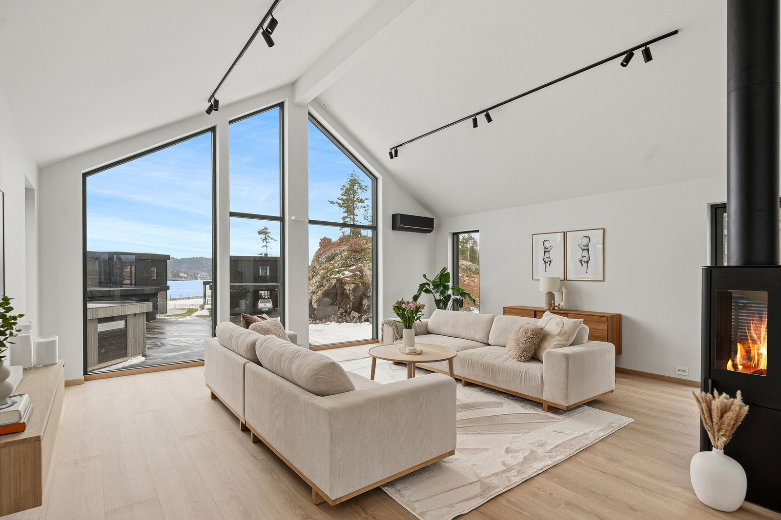 Dagslyset som strømmer inn via store stuevinduer gjenspeiles fint i de hvitmalte overflatene. Galleribilde