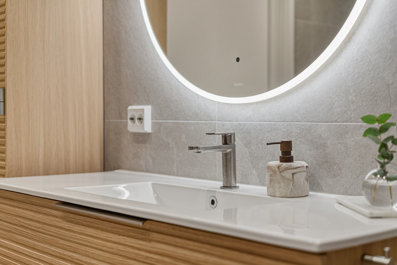 Baderomsinnredningene har gylne, profilerte fronter, og begge badene har speil med dimmbar, integrert belysning. Galleribilde