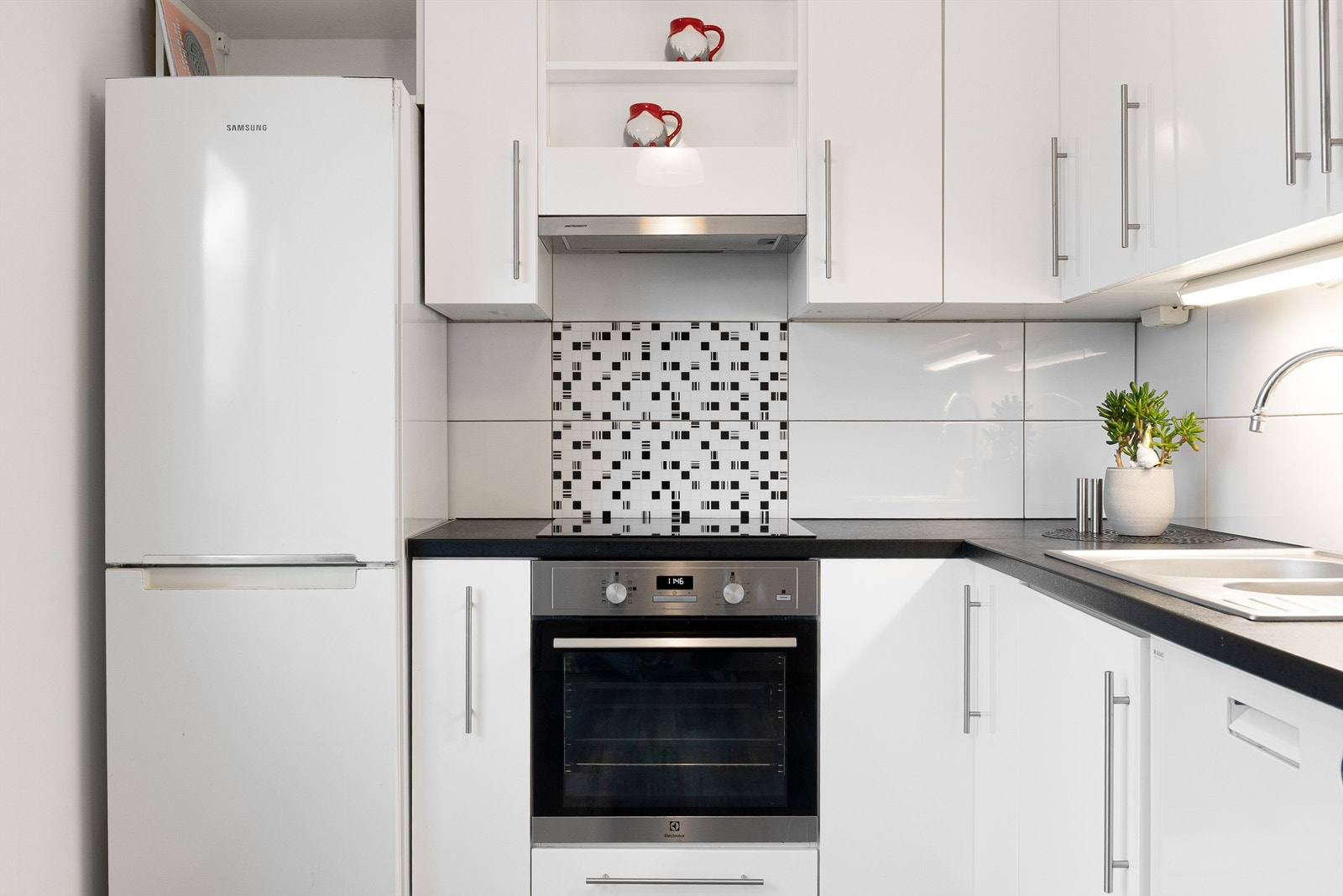 Integrert stekeovn og platetopp. Frittstående oppvaskmaskin og kjøleskap med fryser. Galleribilde