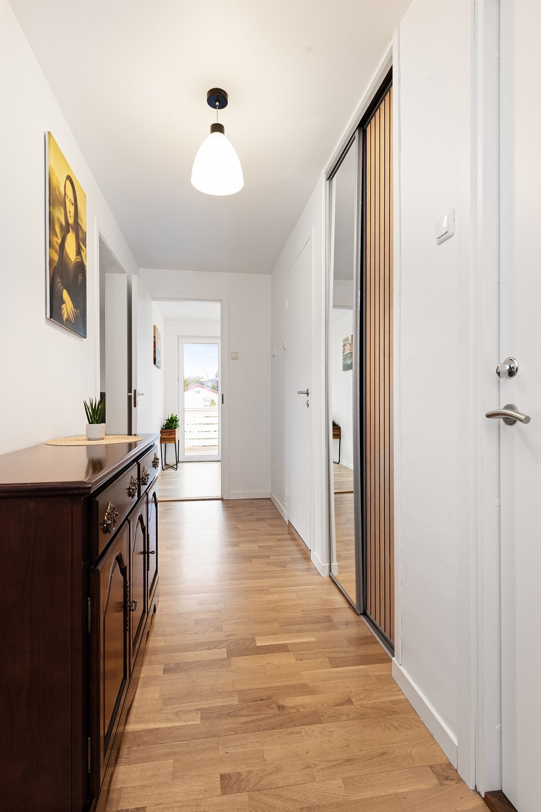 Gang med skyvedørsgarderobe og lyse overflater Galleribilde