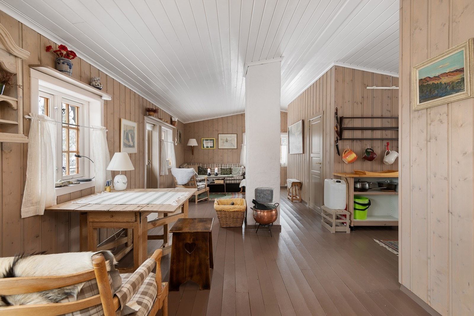 Hytta har romslig stue og spisestue i åpen løsning Galleribilde