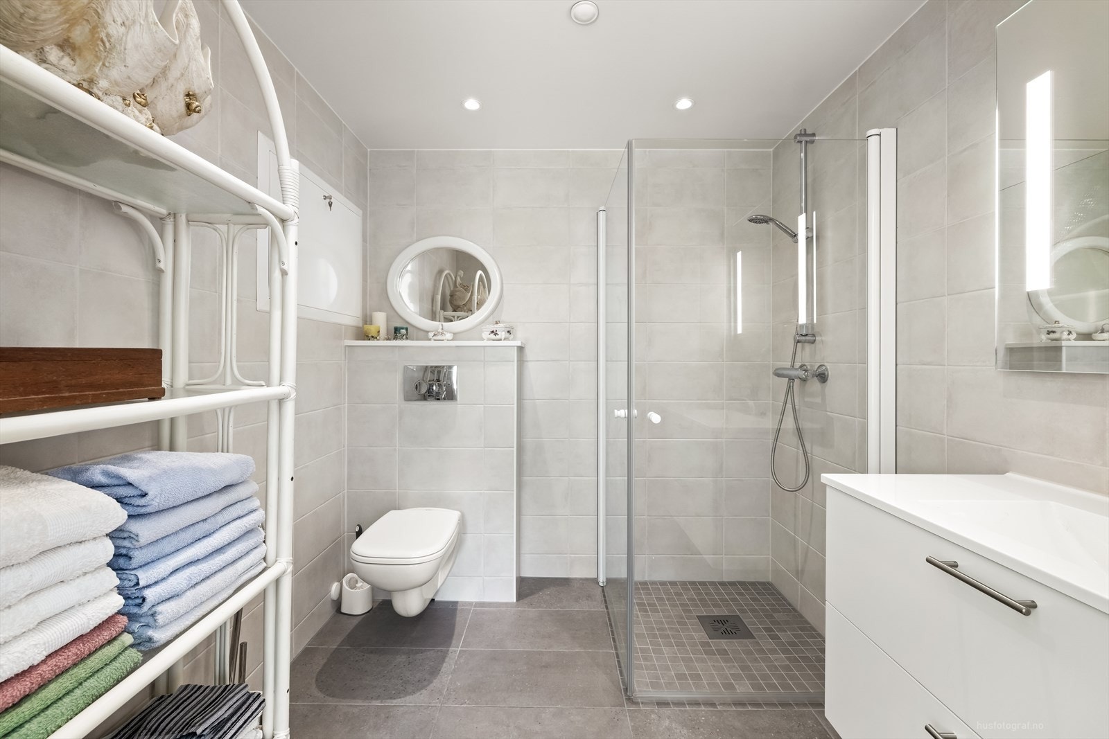 Badet har innredning med nedfelt servant, veggmontert toalett og dusjvegger/hjørne. Galleribilde