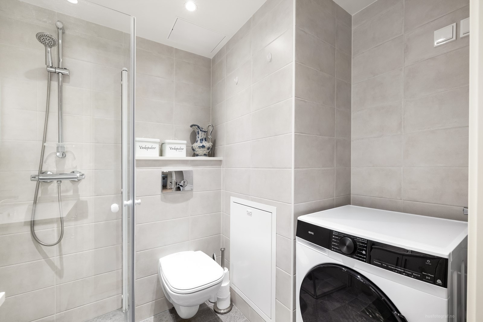 Bad 2 i leiligheten har innredning med veggmontert toalett, dusjvegger/hjørne og opplegg for vaskemaskin. Galleribilde