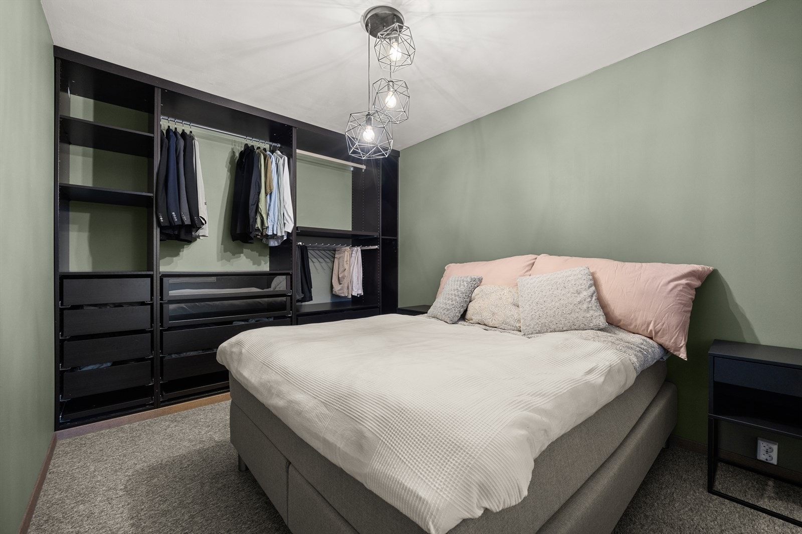 Romslig soverom med plass til dobbeltseng og tilhørende nattbord Galleribilde