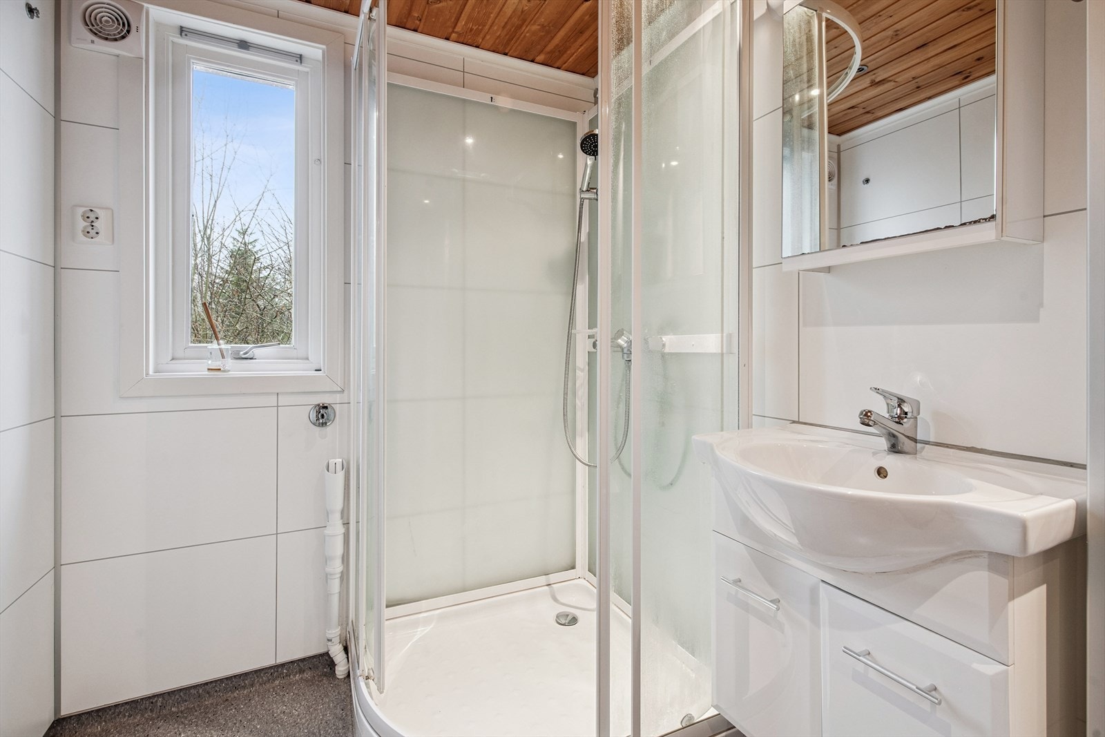 Pent bad med vinylbelegg på gulv og baderomsplater på vegger. Det er varme i gulv. Galleribilde