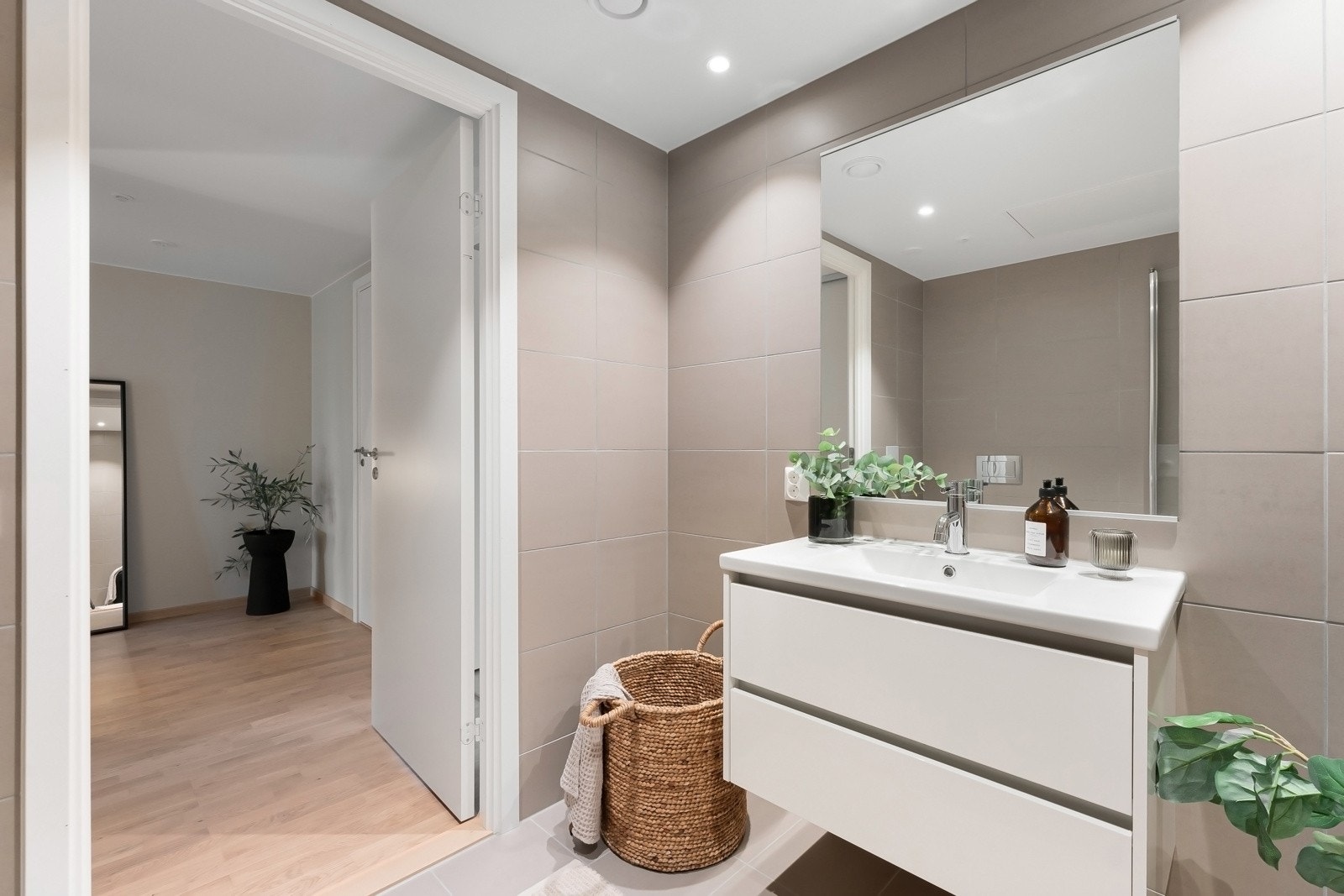 Badet er utstyrt med dusjnisje med glassdører, vegghengt toalett og servant med innredning. Opplegg for vaskemaskin og vannbåren varme i gulv. Galleribilde