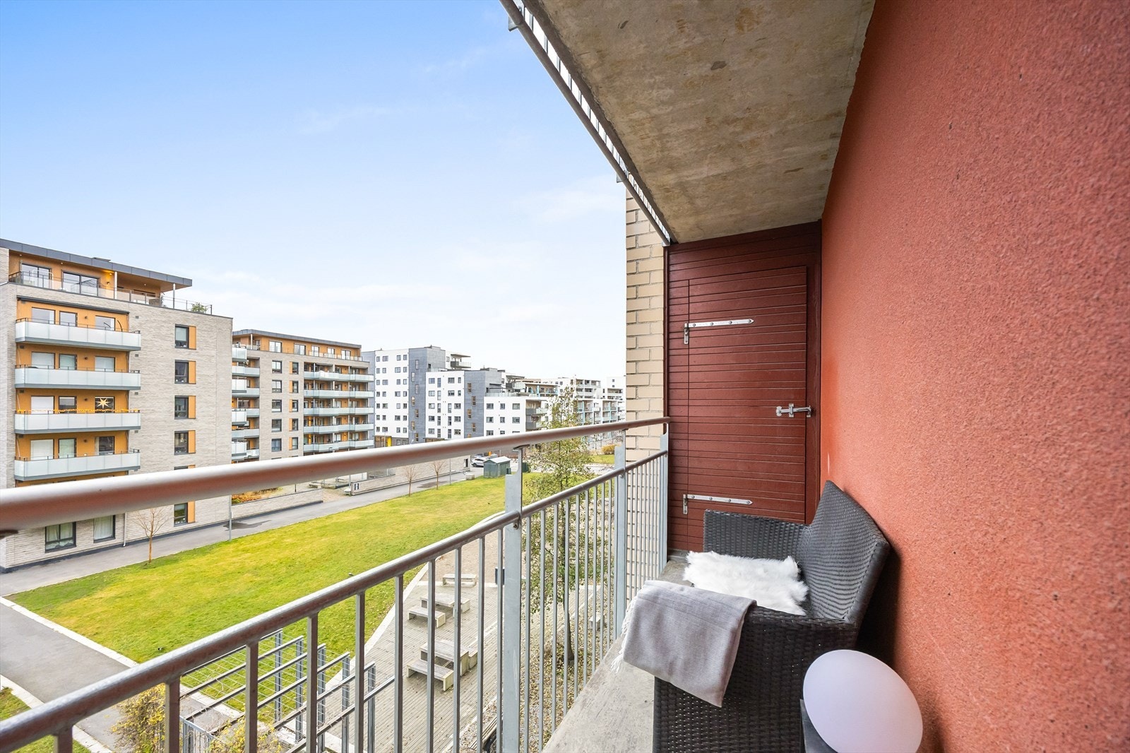 Balkongen er usjenert med utsikt over grøntområdene. Her er også en av to boder tilhørende boligen. Galleribilde