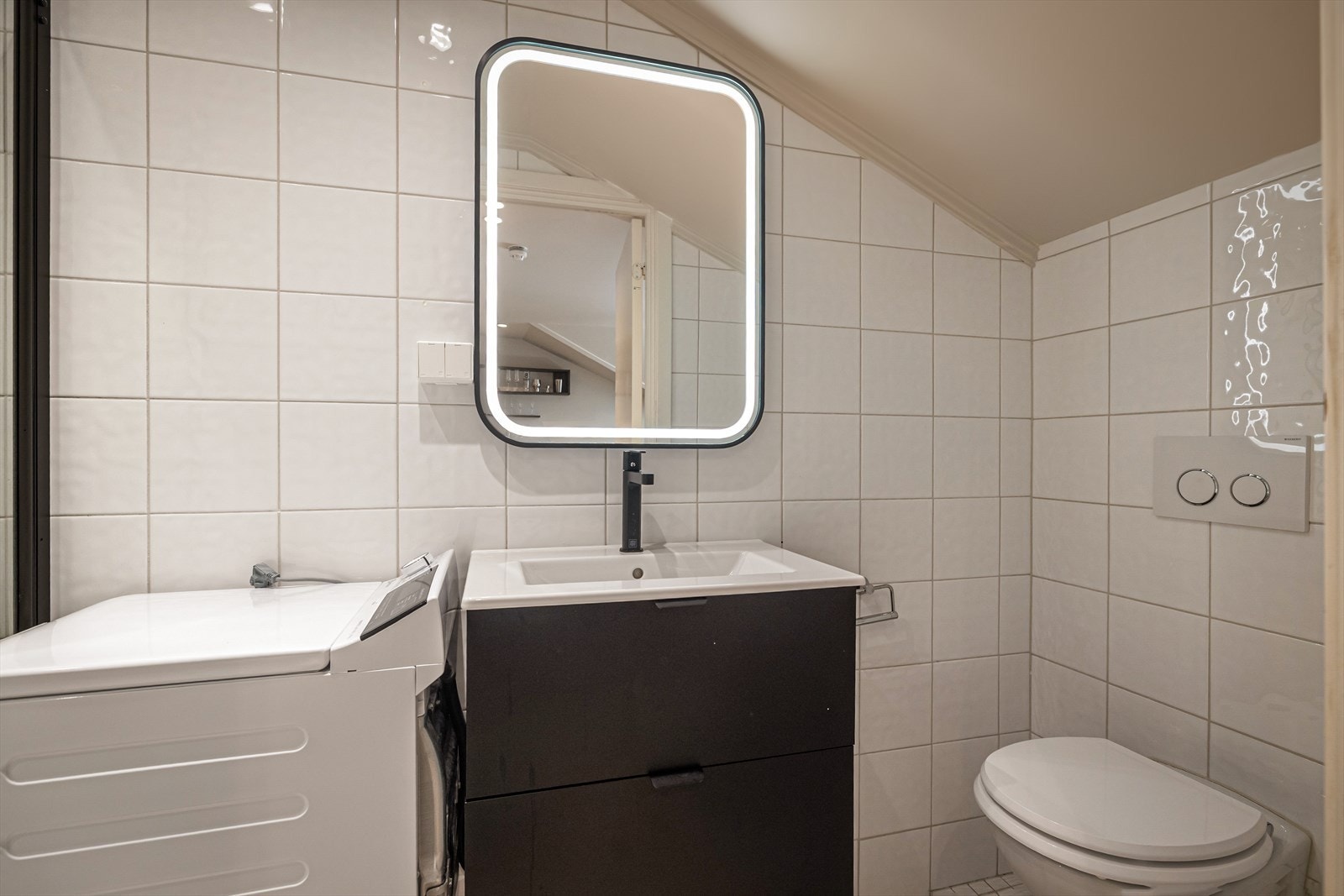 Det er plassbesparende vegghengt toalett med innebygd cisterne, dusj med regnfallsfunksjon og varmekabel i gulv. Ny innredning i 2024. Galleribilde