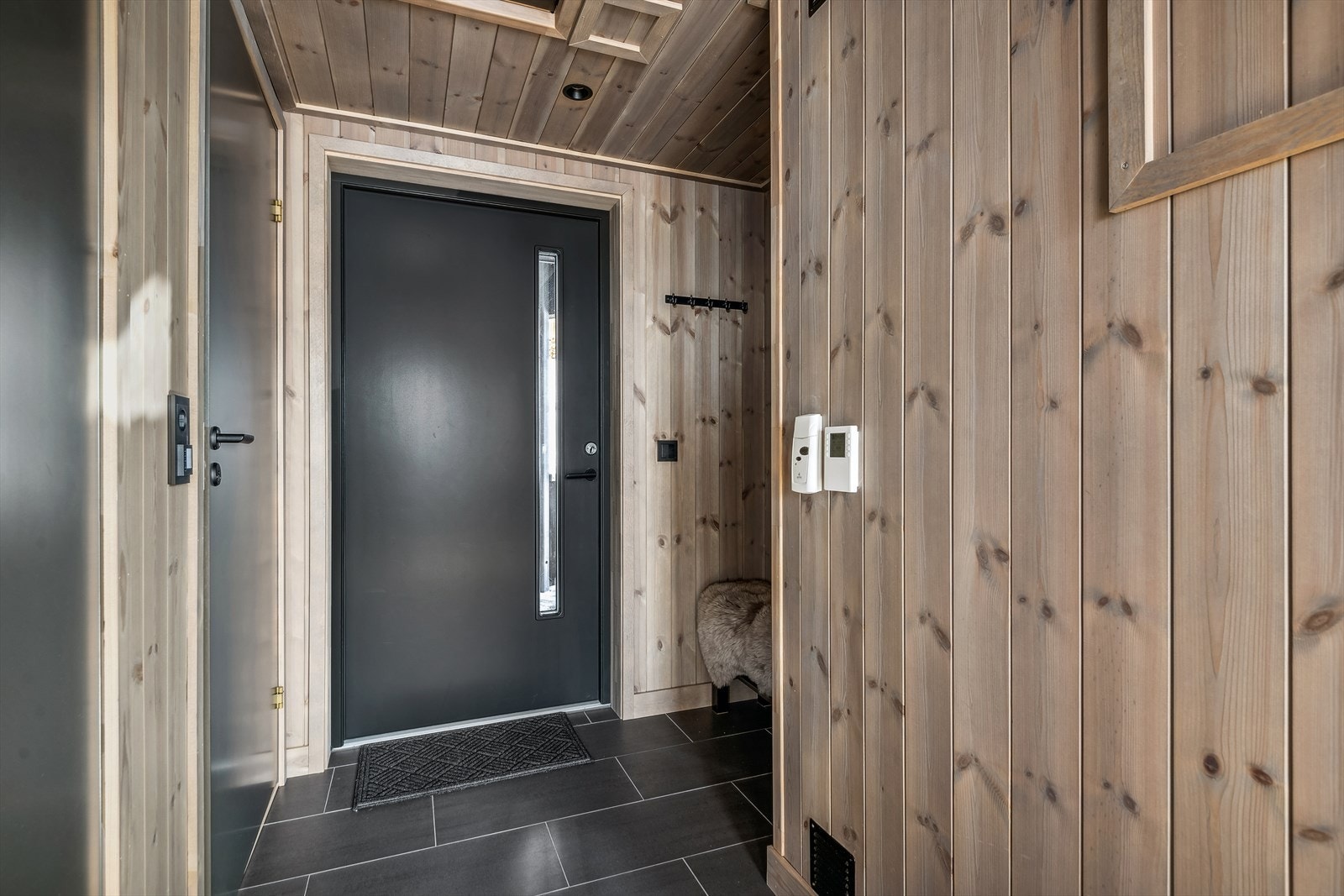 Når du trer inn i leiligheten, blir du møtt av en pen og romslig entré med flislagt gulv og behagelig gulvvarme. Galleribilde