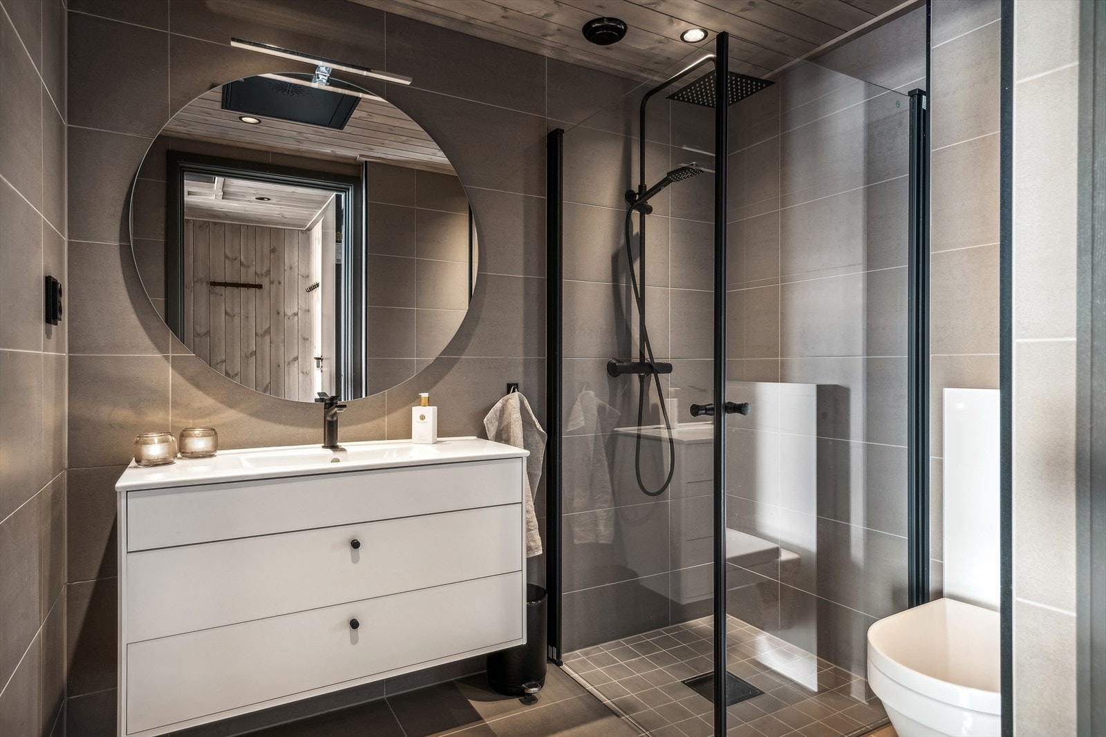 Badet er moderne med sine store, stilige grå fliser og behagelig gulvvarme. Galleribilde