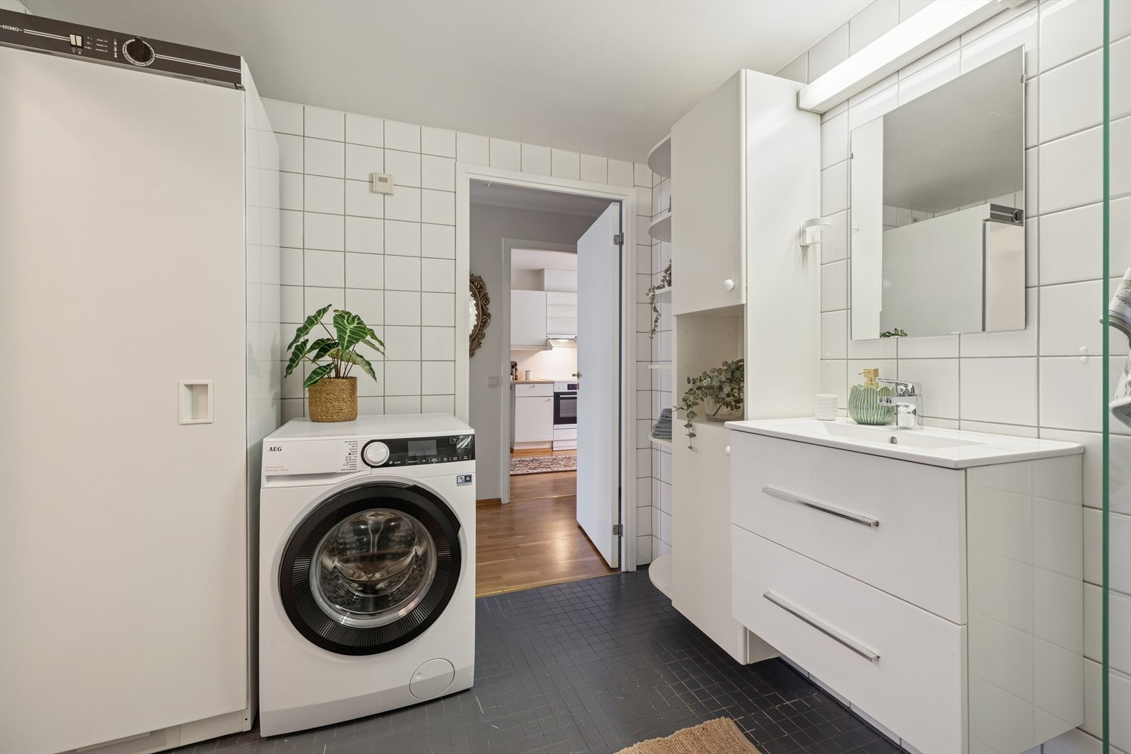 Baderommet er utstyrt med vegghengt klosett, dusj med innfellbare dører og servant med tilhørende skuffer. Galleribilde