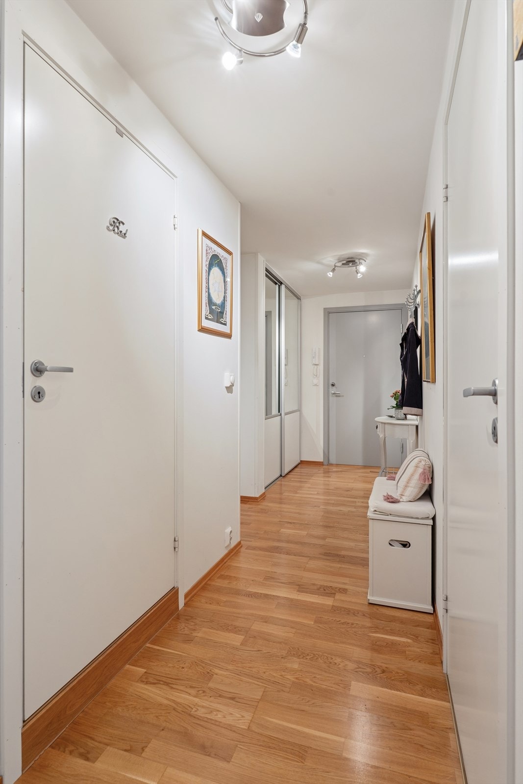 Lys og hyggelig entré med praktisk innebygget skyvedørsgarderobe. Galleribilde