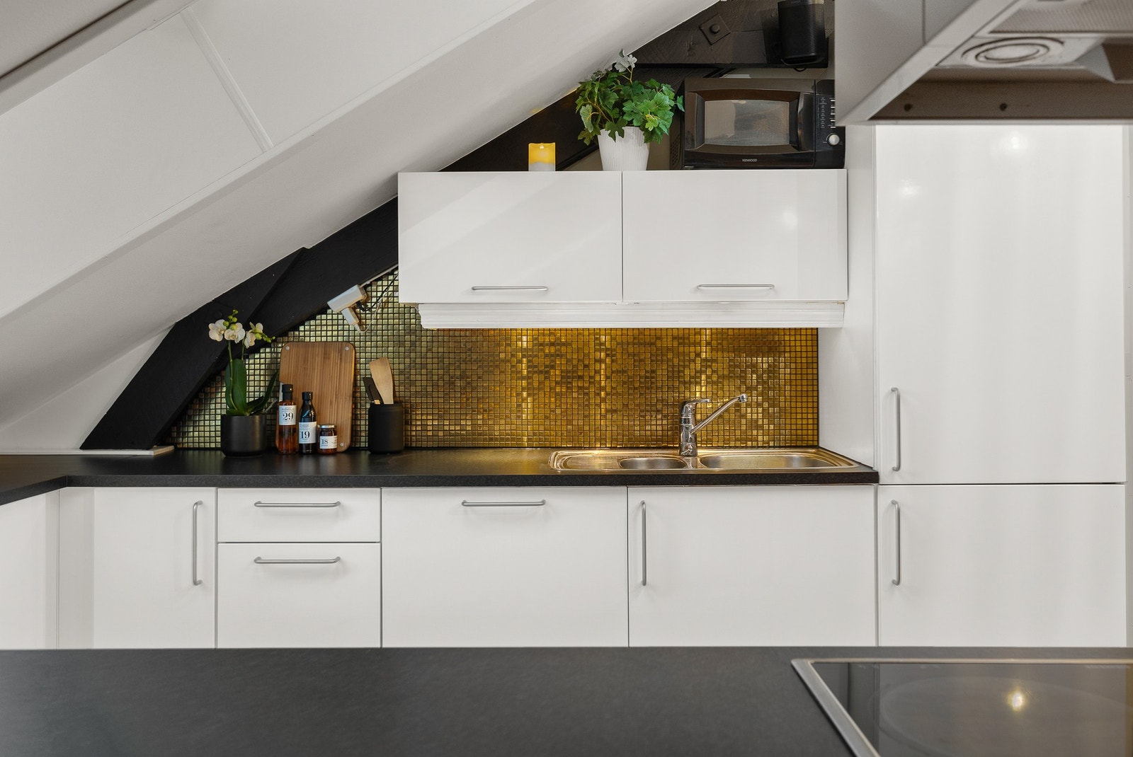 Kjøkkenets utrykk komplementers godt med lekker flislagt backsplash. Galleribilde