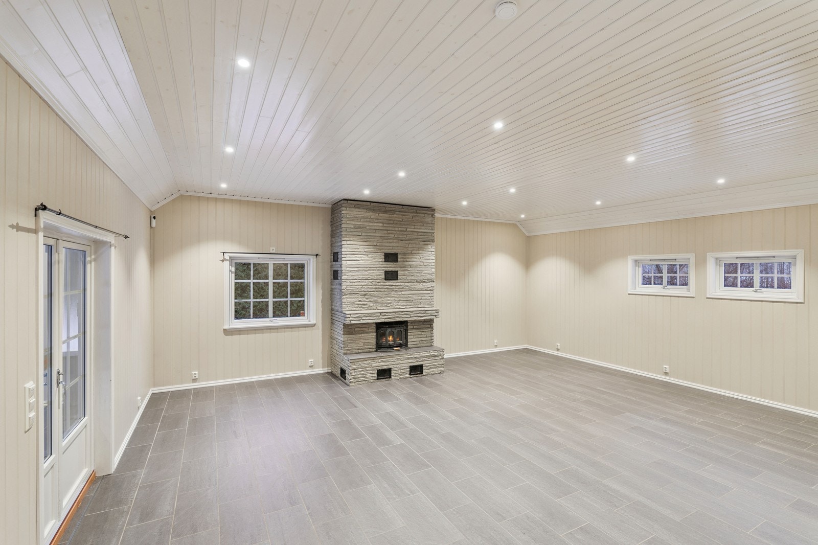 Flott og romslig stue med murt peis og direkte utgang til uteområder Galleribilde