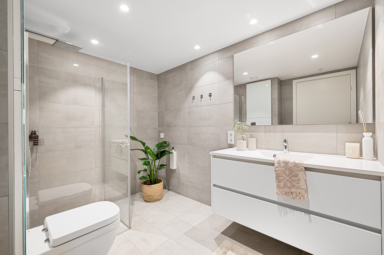 Lekkert og stilrent flislagt bad med gjennomtenkte løsninger. Badet er oppgradert av utbygger og fremstår som både moderne, praktisk og elegant. Galleribilde