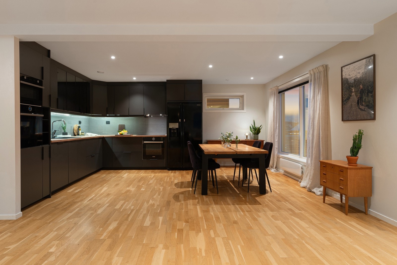 God plass til stort spisebord i overgang stue/kjøkken.