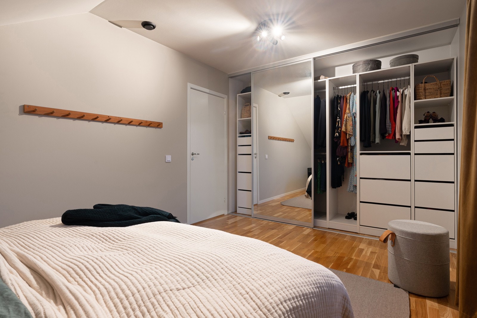 Romslig hovedsoverom med skyvedørsgarderobe.