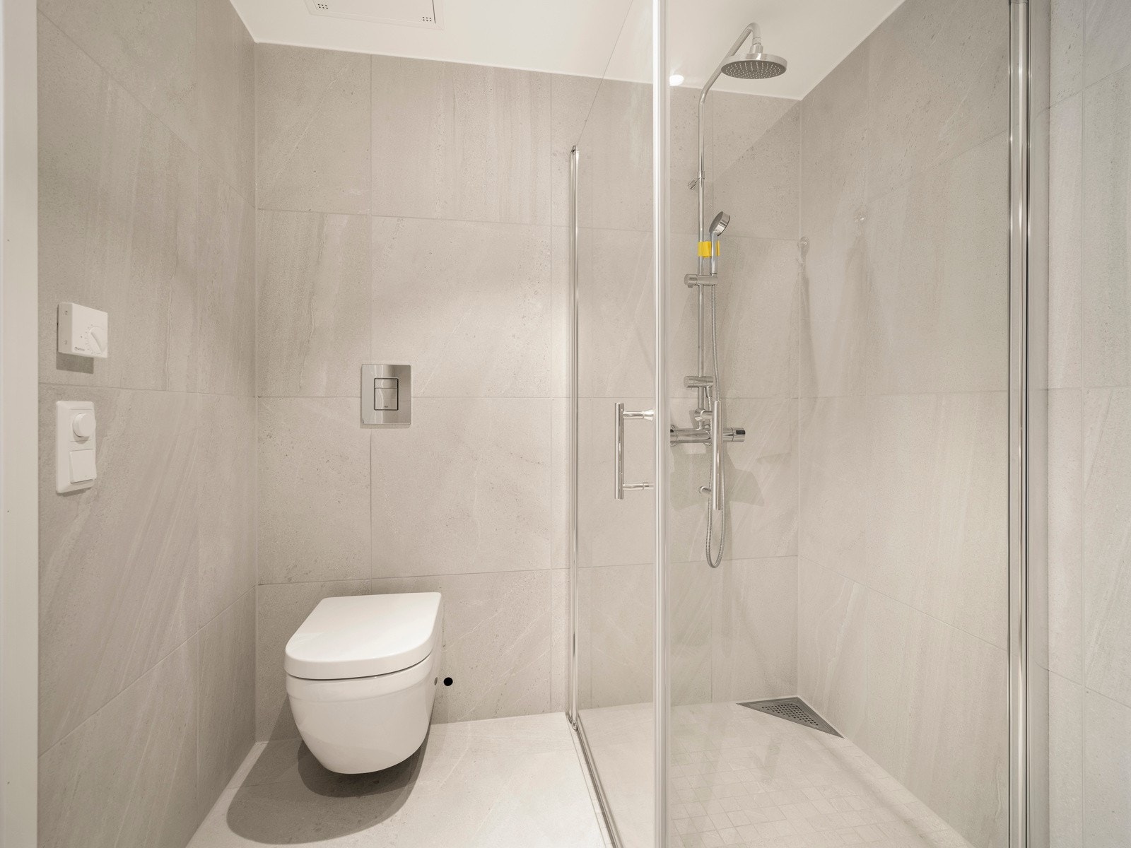 Regndusj i krom, vannbåren varme i gulvet og moderne armaturer gir et funksjonelt og elegant bad med god plass til både gjester og daglig bruk. Galleribilde