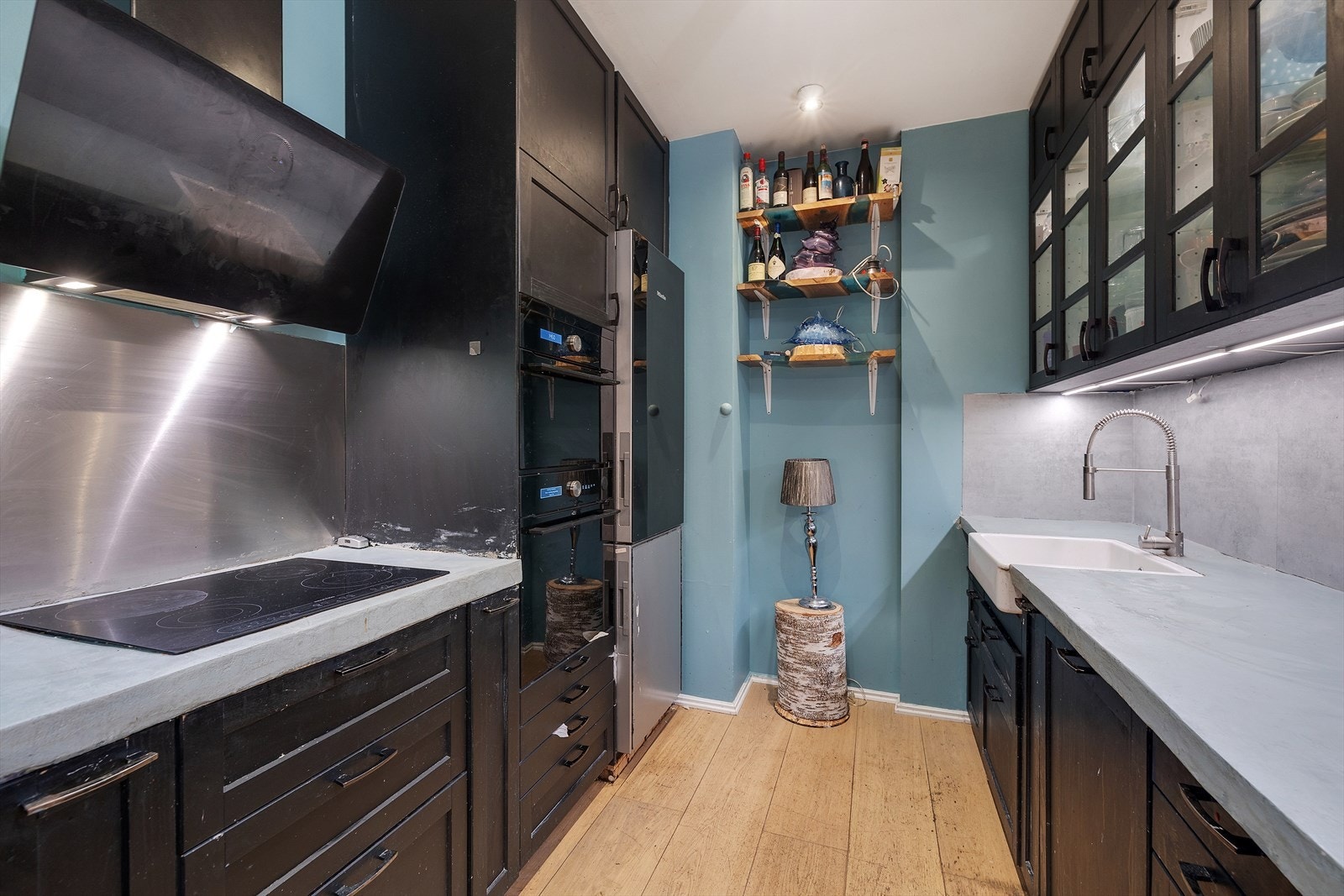 Slettmalte vegger og laminatgulv gir kjøkkenet et funksjonelt preg, med komfyrvakt og automatisk lekkasjesikring. Galleribilde